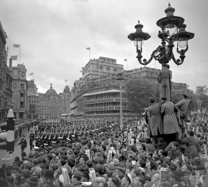 Crowds in Trafalgar Square in the rain watch as troops march past on the return from Westminster Abbey after the Queen's crowning.