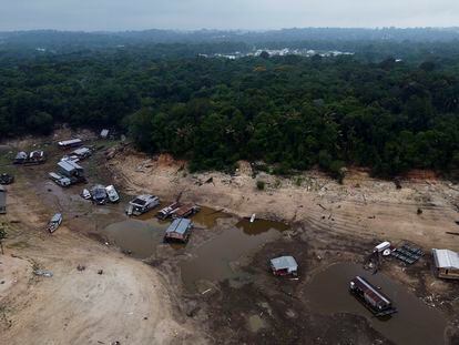 Boats and houseboats are stuck in a dry area of the Negro River during a drought in Manaus, Amazonas state, Brazil, Monday, Oct. 16, 2023.