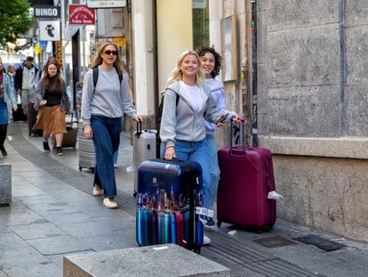 Tourists with suitcases on Carretas street in Madrid.
