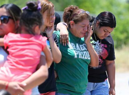 María López wipes away tears as she joins her daughters Alyssa and Marisa near the scene where 53 migrants were found dead inside a tractor trailer.