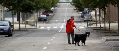 A man walks his dog in the deserted streets of Ciudad Valdeluz in the municipality of Yebes.