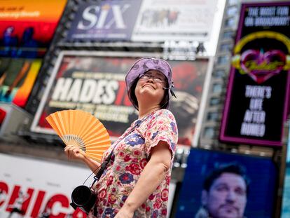 A tour guide fans herself while working in Times Square as temperatures rise, July 27, 2023, in New York.