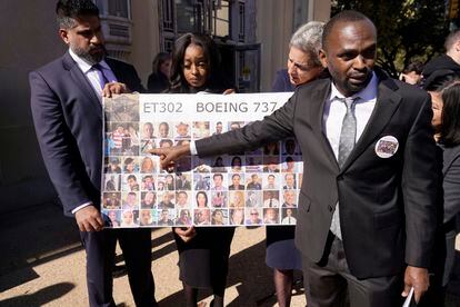 Paul Njoroge, right, points to photos of his wife and three children that were killed in the 2019 crash of Ethiopian Airlines 737 Max aircraft after a federal court hearing in Fort Worth, Texas, Thursday, Jan. 26, 2023.