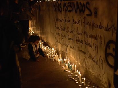 A girl places a candle during the tribute at the National Stadium on Monday.