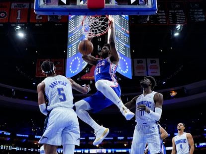 Joel Embiid of the Sixers dunks against Paolo Banchero of the Magic.