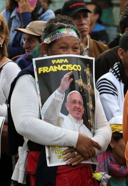 A woman hold a poster of the pope.