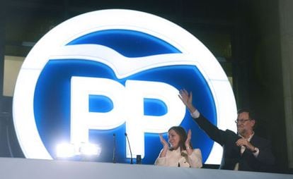 Prime Minister Mariano Rajoy waves next to his wife Elvira Fernandez at PP headquarters on Sunday night.