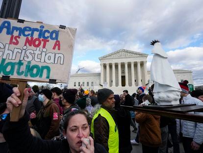 An abortion rights activist, left, protests as people carry a statue of Our Lady of Fatima outside of the U.S. Supreme Court during the March for Life, Friday, Jan. 20, 2023, in Washington.