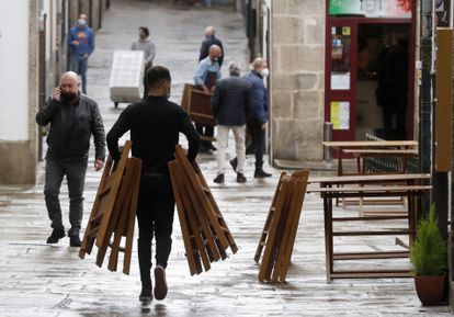A waiter setting up a sidewalk café in Galicia in October 2020. The region will relax restrictions on the hostelry industry from Friday.