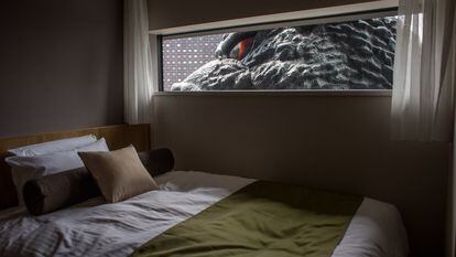 The eye of a 40-foot-tall Godzilla replica peaks through the window of a hotel in Tokyo.