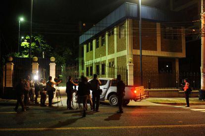Reporters wait outside police headquarters in San Salvador.