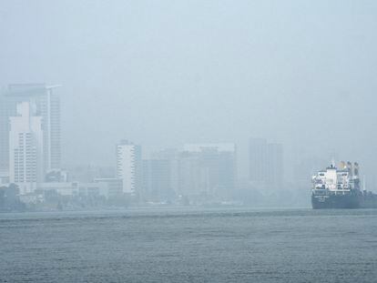 A freighter passes through the Detroit River as smoke fills the sky reducing visibility to Windsor, Ontario, on June 28, 2023, as seen from Detroit.