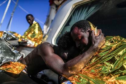 Two of the rescued men hug each other on board the 'Astral' on Monday.