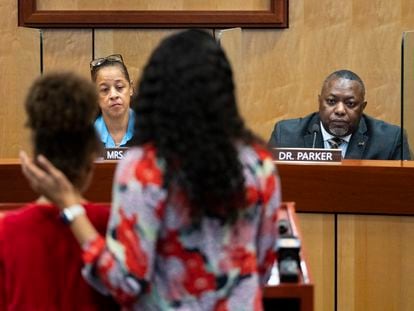 Djifa lee, a second-grade teacher at Saunders Elementary, center, stands with her daughter as she speaks in front of the Newport News School Board at the Newport News Public Schools Administration building on Tuesday.
