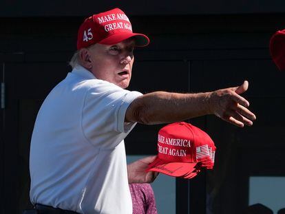 Former President Donald Trump throws autographed caps to the crowd during the final round of the Bedminster Invitational LIV Golf tournament in Bedminster, N.J., Sunday, Aug. 13, 2023.