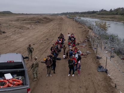 Migrants wait to be processed, after crossing the Rio Grande, in Eagle Pass (Texas).