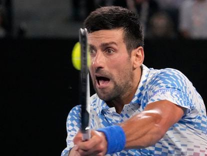 Novak Djokovic of Serbia plays a backhand return to Andrey Rublev of Russia during their quarterfinal match at the Australian Open tennis championship in Melbourne, Australia, Wednesday, Jan. 25, 2023.