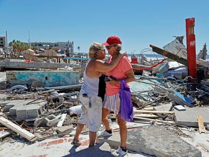 Two women who have lost their businesses embrace after Hurricane Ian passes through the island of Fort Myers Beach, Florida, on September 30, 2022.