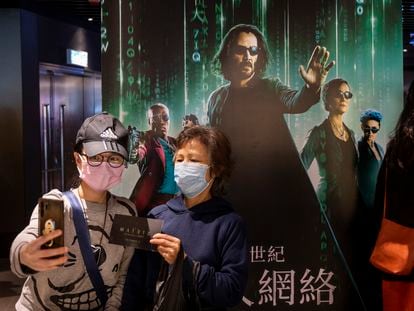 Moviegoers take a selfie in front of a movie banner for ‘The Matrix Resurrections’ at a cinema in Hong Kong.