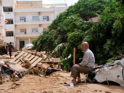 A man sits on a destroyed car, after the flood in Derna, Tuesday, September 12, 2023.