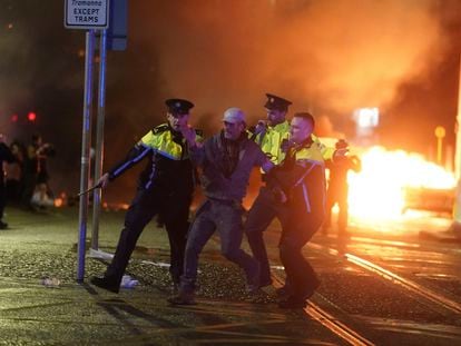 Three police officers arrest a protestor in Dublin, on Thursday, November 23, 2023.