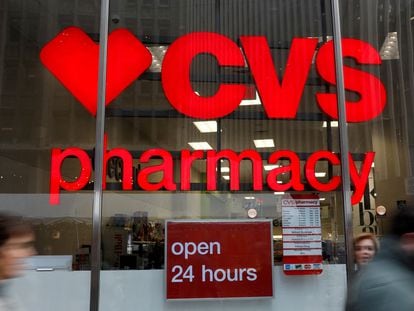 People walk by a CVS Pharmacy store in the Manhattan borough of New York City, November 30, 2017.