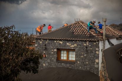 Volunteers clear away ash from a home in La Palma.