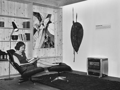 A woman sits in an Eames chair at the New Homes Show at Central Hall, Westminster (UK), June 25, 1963.