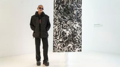 Alexis Martínez poses next to his work 'IMMURED' at the Hilario Galgera gallery on November 23, 2023.
