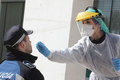 A health worker tests a police officer for Covid-19 in Madrid.