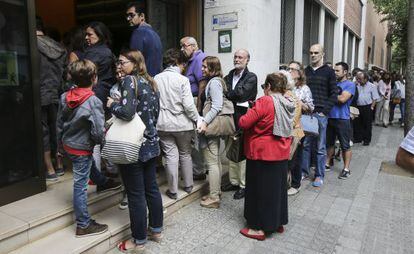 Lines of voters outside a polling station on Barcelona's Travessera de les Corts.