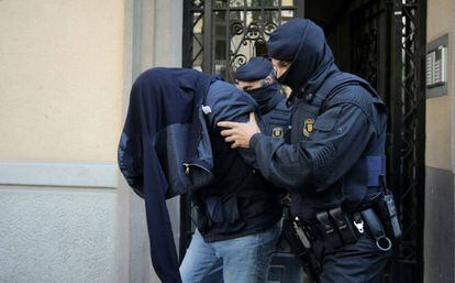 Police with one of the suspects arrested in Barcelona.