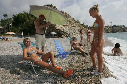 Russian tourists chill out on the beach in Vila Joiosa in the province of Alicante.