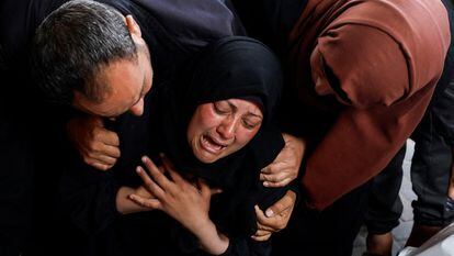 A woman cries next to Palestinians killed by an Israeli bombing in Rafah on Tuesday.