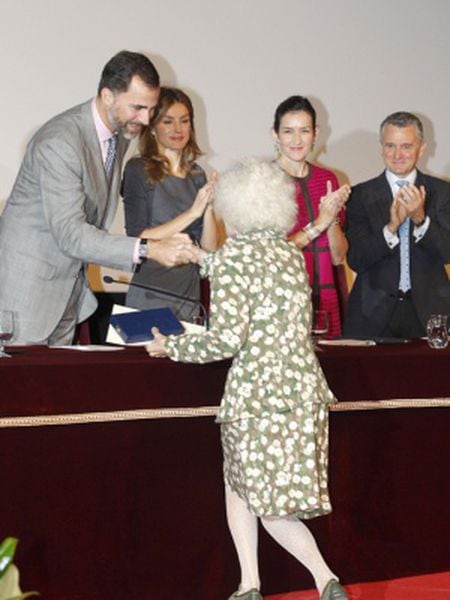 The Duchess of Alba curtsies before the king and queen of Spain.
