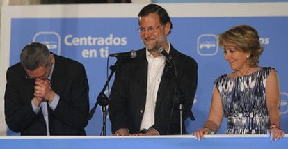 PP leaders Gallardón, Rajoy and Aguirre salute the crowd from party headquarters on Sunday night.