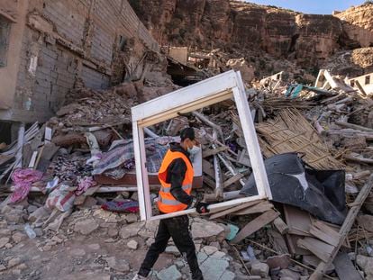 A volunteer helps salvage furniture from homes which were damaged by the earthquake, in the town of Imi N'tala, outside Marrakech, Morocco, Wednesday, Sept. 13, 2023.