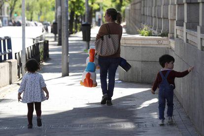 A mother takes her children for a walk in Madrid. 