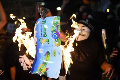 Protesters burn a World Cup brochure in Rio de Janeiro.