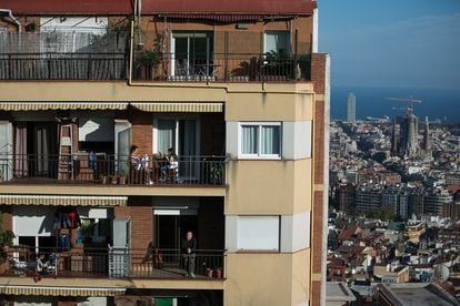 The residents of an apartment block in Barcelona sit out on their balconies during quarantine.