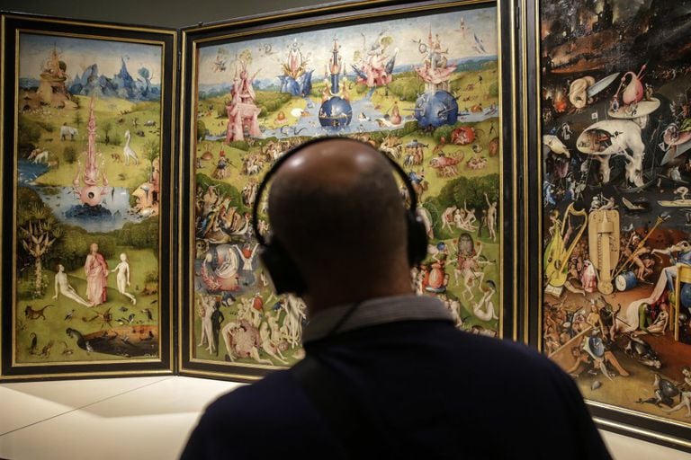 A visitor admires 'The Garden of Earthly Delights' by Hieronymus Bosch.
