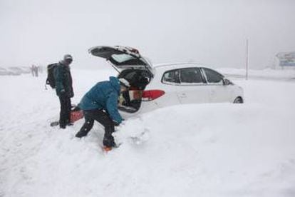 Two people dig their car out from the snow in Navacerrada, Madrid.