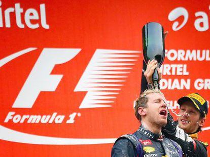Sebastian Vettel (front) celebrates on the podium, with Romain Grosjean of Lotus F1 Team.