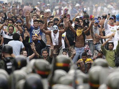 Supporters of Capriles face off with riot police in Caracas on Tuesday.