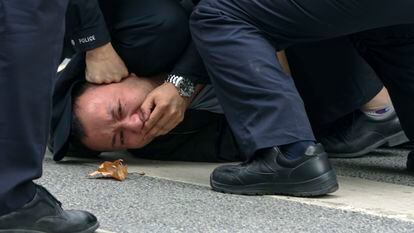 Police subduing a man during a protest in Shanghai on November 27.