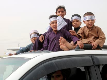 Children hold Taliban flags during a celebration