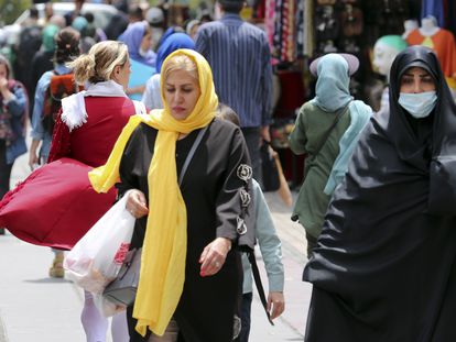 Iranian women, wearing a veil, walks among other pedestrians along a street in Tehran, Iran, in May 2023.