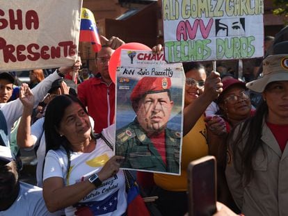 A woman carries a portrait of late Venezuelan President Hugo Chavez during a caravan in Caracas on March 15, 2023.