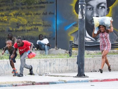 Several people run from a shooting near the National Palace in Port-au-Prince, on March 21.