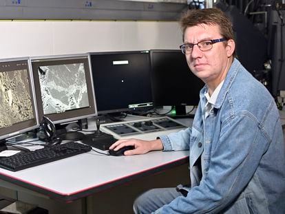Researcher Georgy Belyanin sits in front of monitors that display images of backscattered electrons, which reflect the chemical composition of the Hypatia stone.